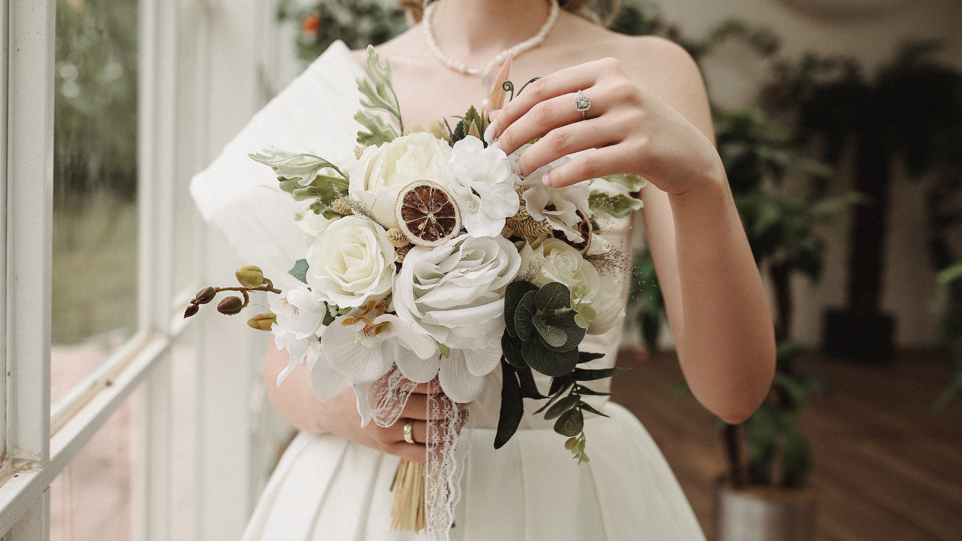 mariée qui tient un bouquet de fleurs séchées