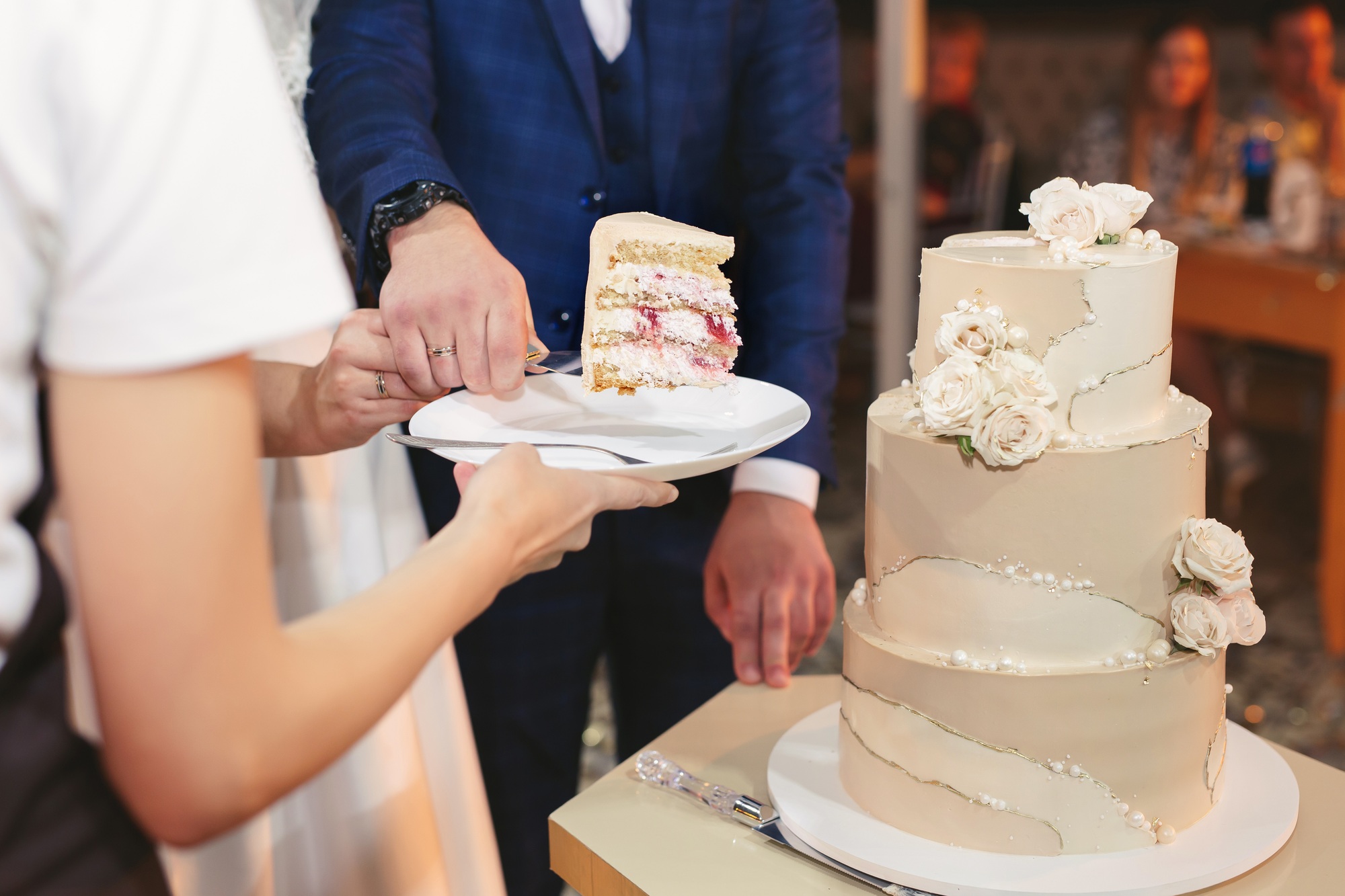 The bride and groom cut a gorgeous wedding cake at a banquet