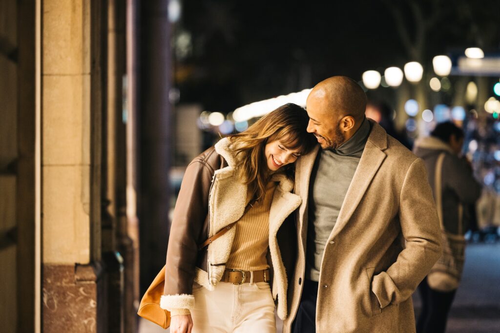 Happy couple enjoys a night out shopping together in the city