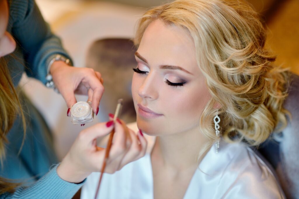 Wedding makeup artist making a make up for bride